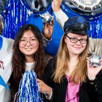 Students pose with props in photo booth